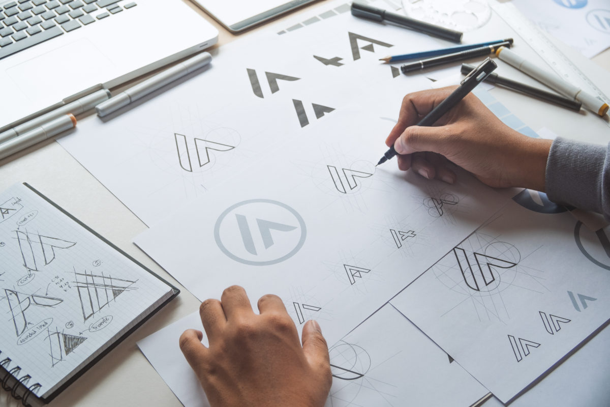 An close-up image on a designer's hands as they work on logo mock-ups