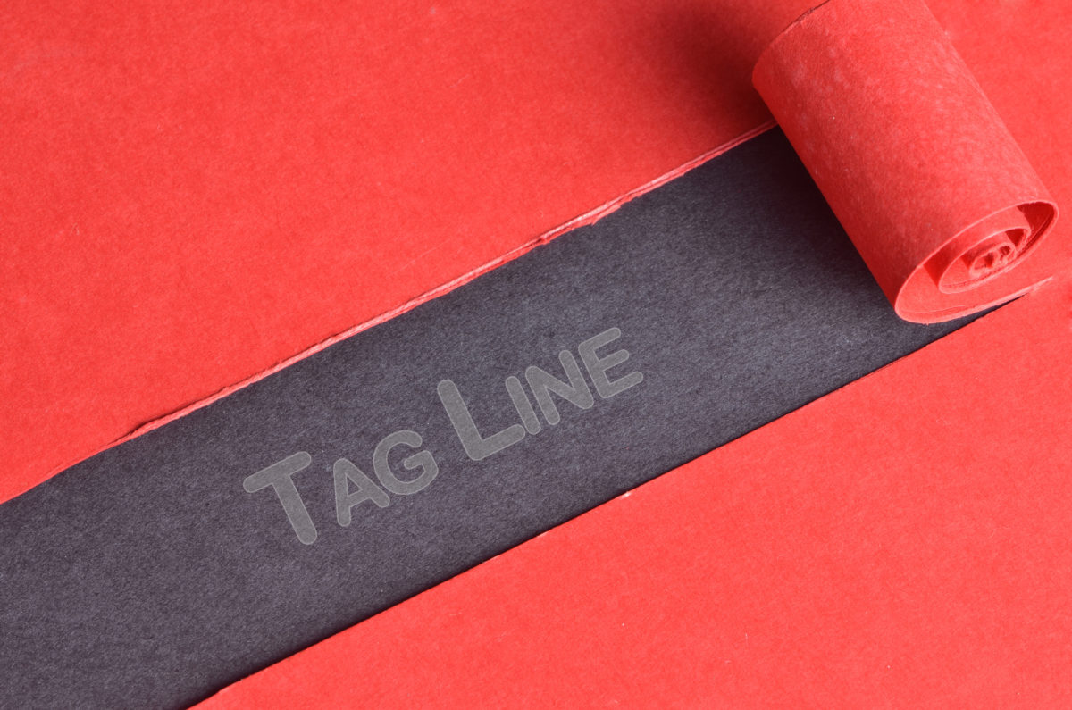 A solid red paper with a middle section peeling back, revealing the word "tagline"