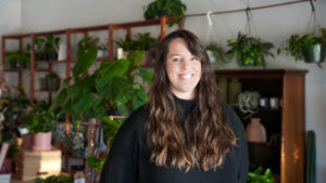Ida Uffelman, owner of Spruce, stands in front of the plants within her shop