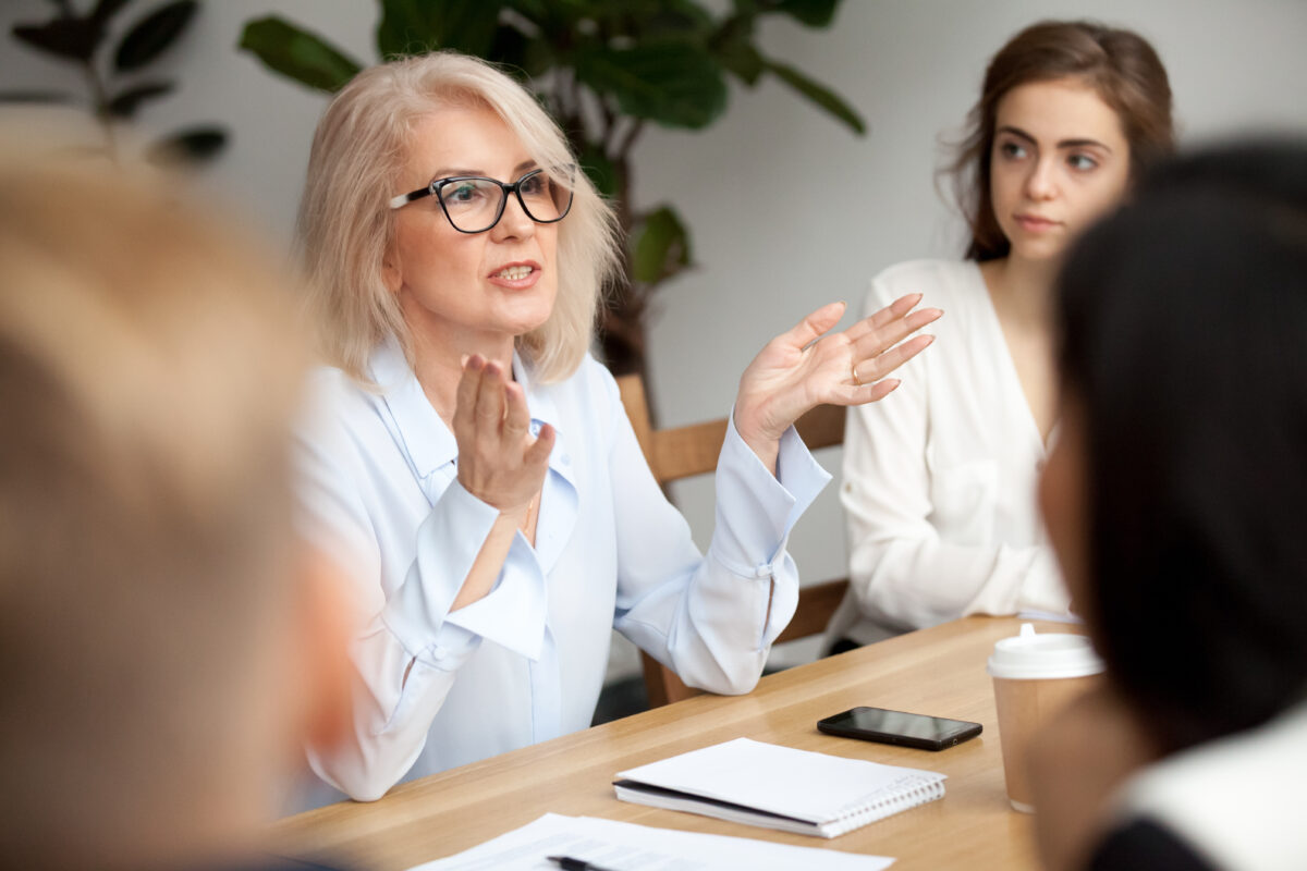 A middle aged business woman leads a meeting