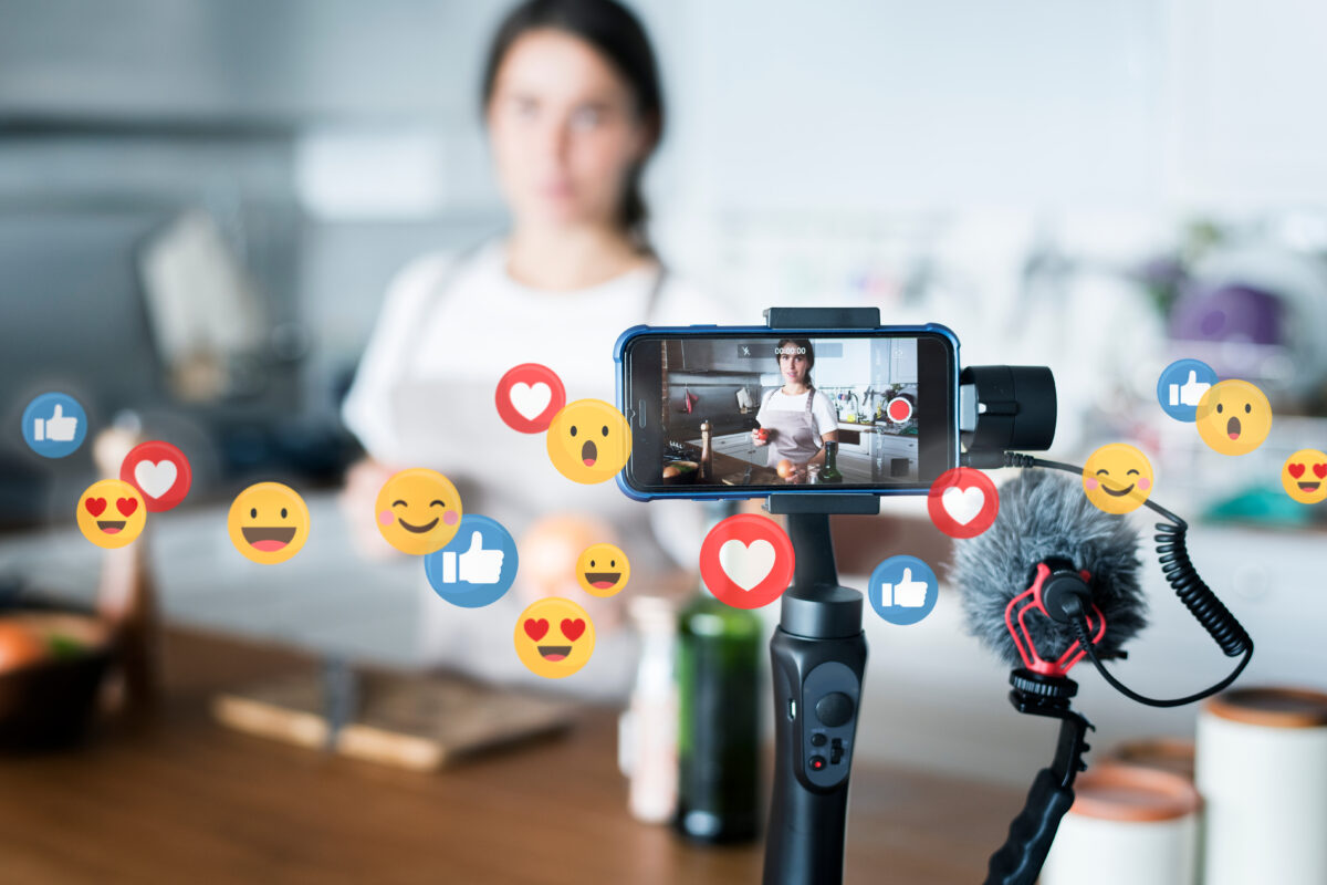 A woman stands in front the of a video camera for a social media video production